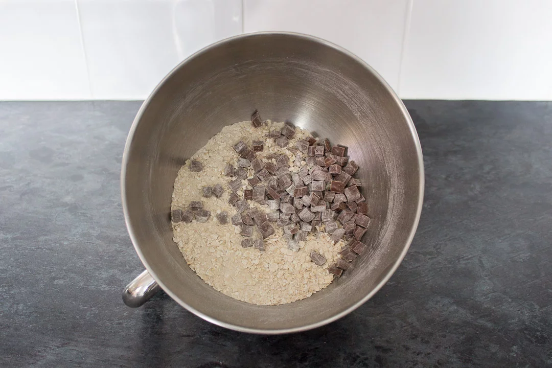 flour, sugar, oats, salt, bicarbonate of soda and chocolate chips in the bowl of a stand mixer