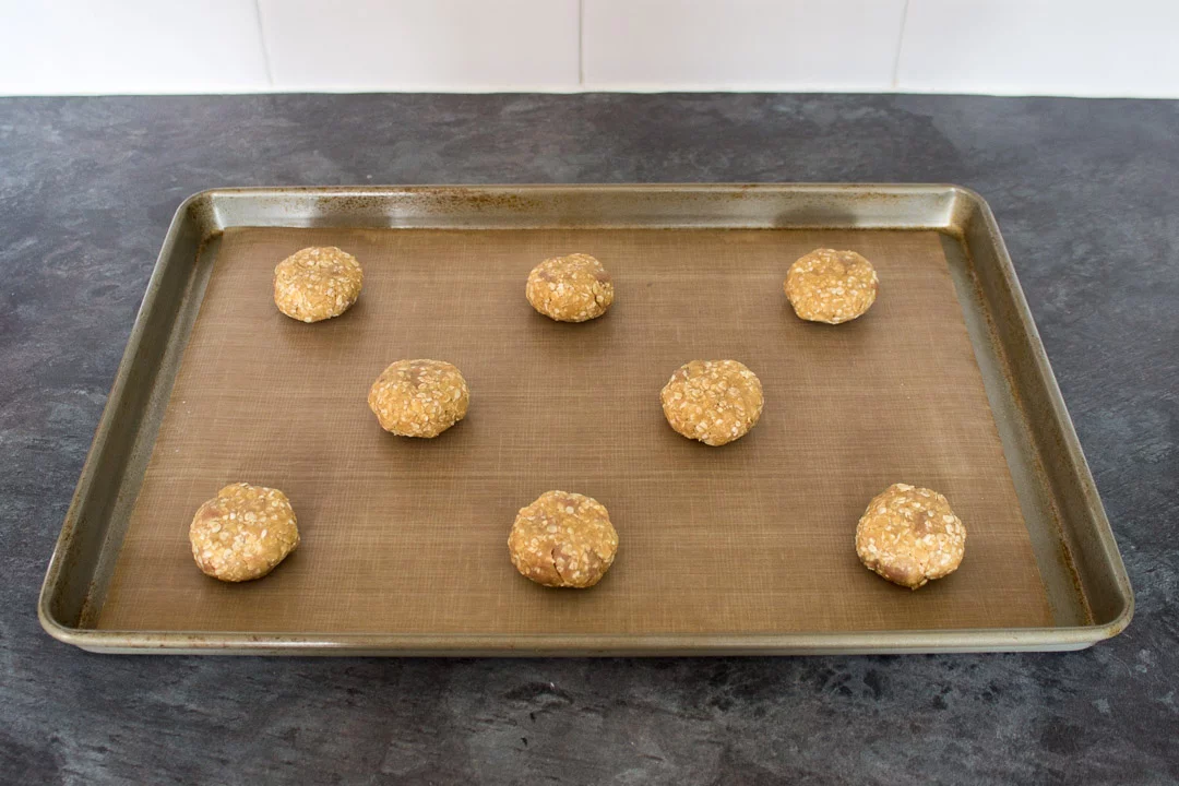 Chocolate hobnobs cookie dough balls on a lined baking tray