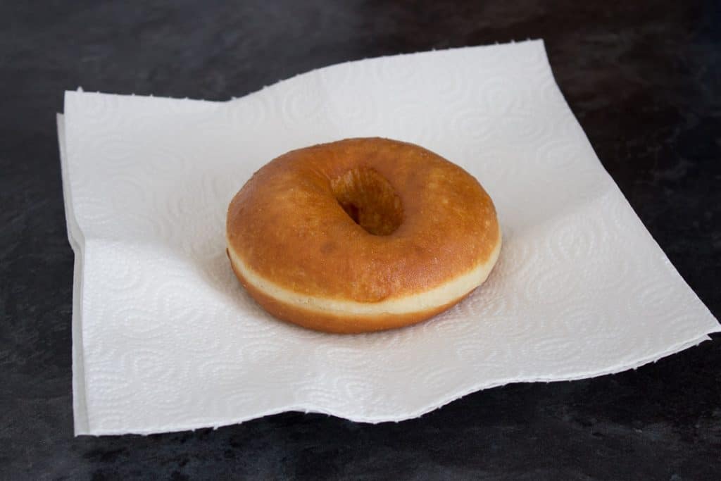 freshly fried homemade doughnut on a piece of kitchen roll