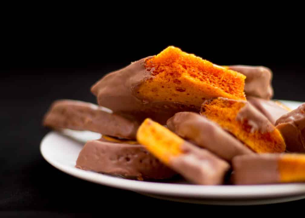 Chocolate covered cinder toffee on a plate.
