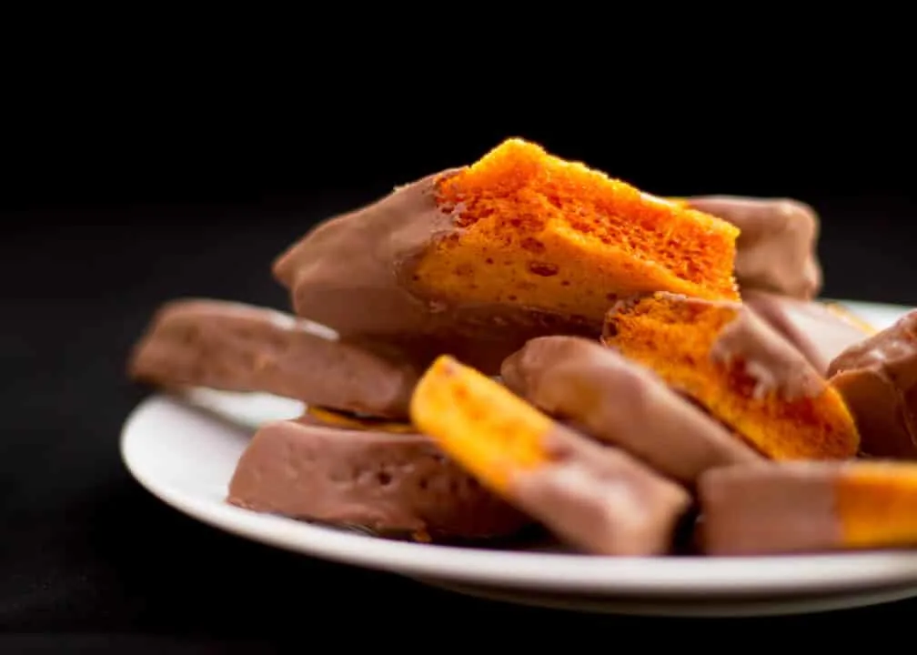 Chocolate covered cinder toffee on a plate.