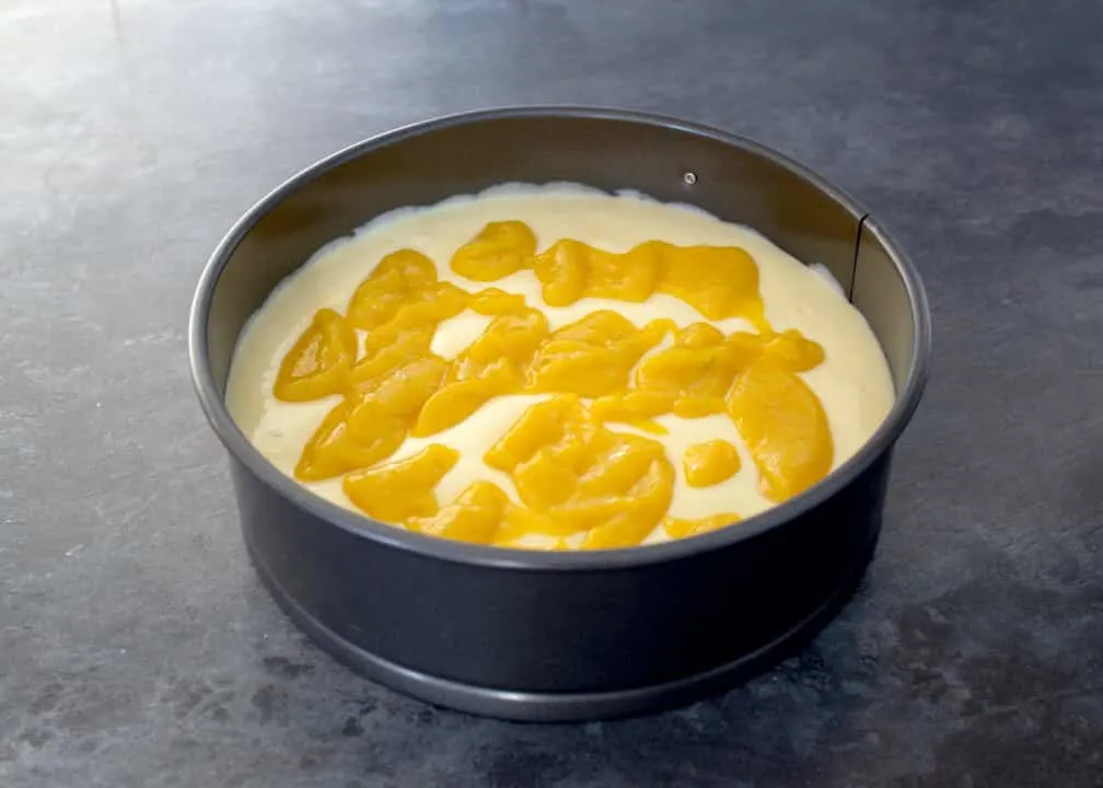 Mango & White Chocolate Cheesecake: mango puree topping on top of the prepared cheesecake filling