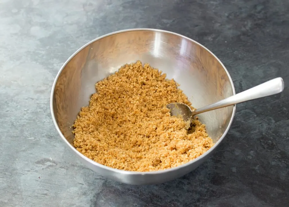 Mango & White Chocolate Cheesecake: base crumbs in a bowl