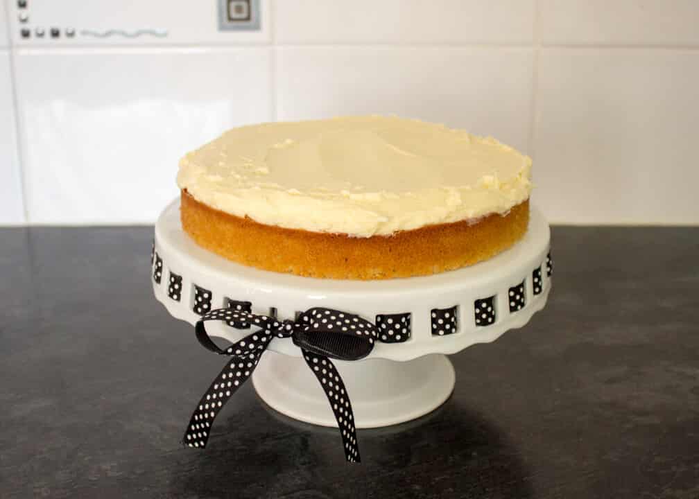 Victoria Sandwich Cake being assembled on a cake stand