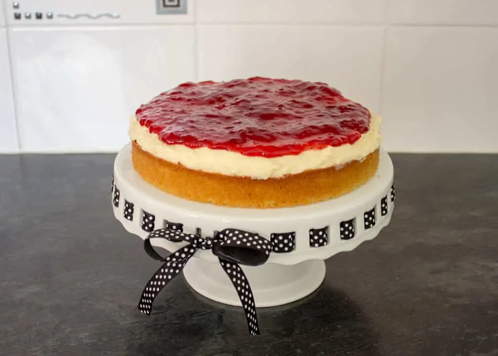 Victoria Sandwich Cake being assembled on a cake stand