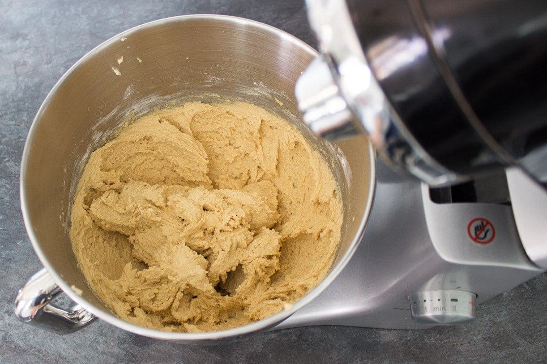 peanut butter cookie dough in the bowl of an electric stand mixer