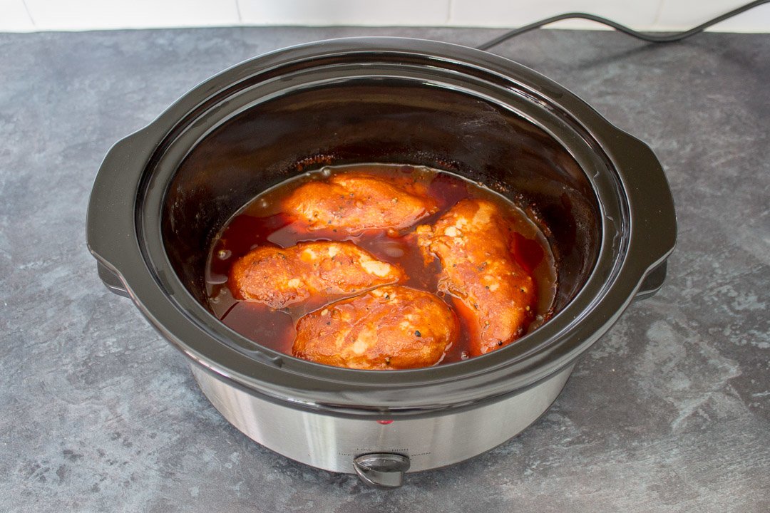 Slow cooker bbq chicken in a slow cooker before being shredded