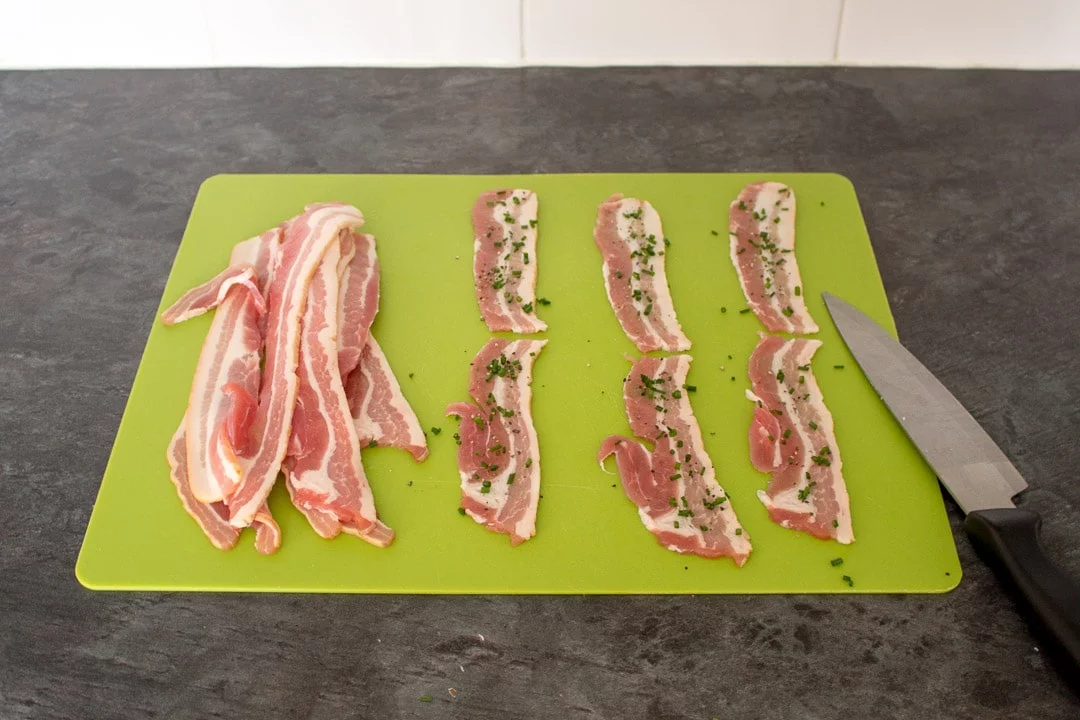 Bacon Halloumi Bites: Bacon rashers on a chopping board with chives