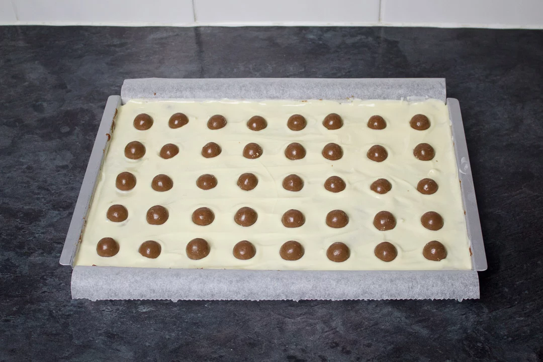 Malteser tiffin topped with Maltesers ready to be placed in the fridge to set