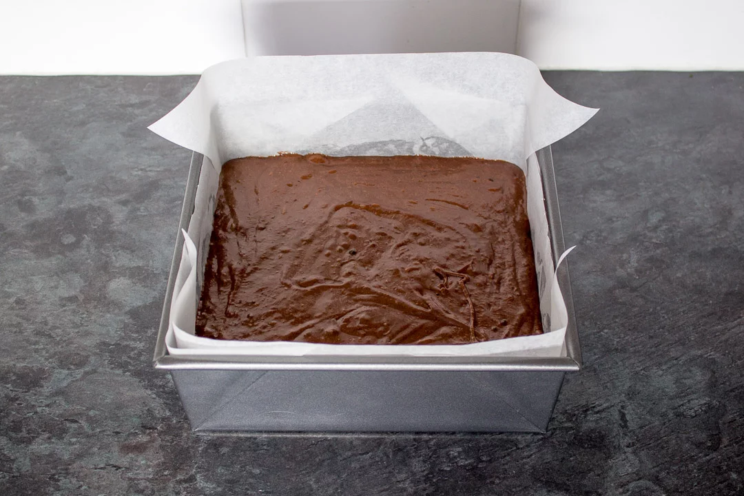 creme egg brownie batter in a lined, square baking tin