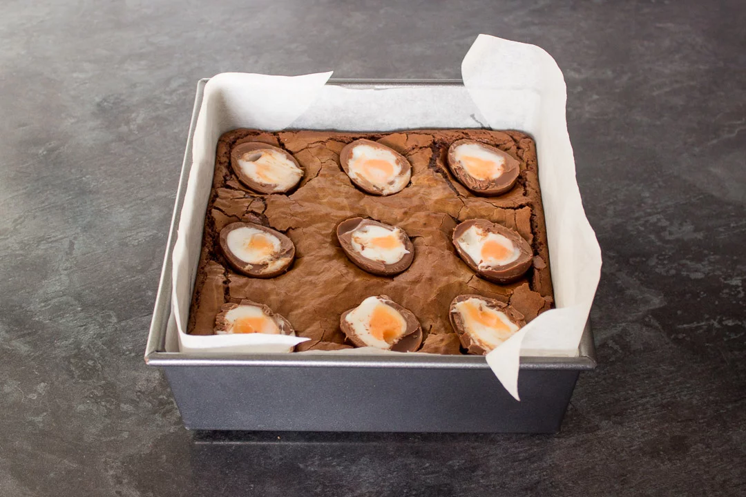 part cooked brownies with halved creme eggs pushed slightly into the top