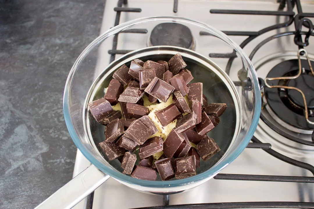 dark chocolate and butter in a glass bowl set over a pan of barely simmering water