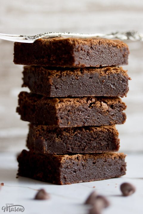 fudgy brownies in a stack with a fork on top