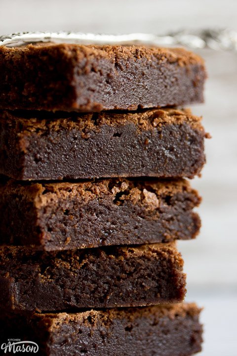 fudgy brownies in a stack with a fork on top