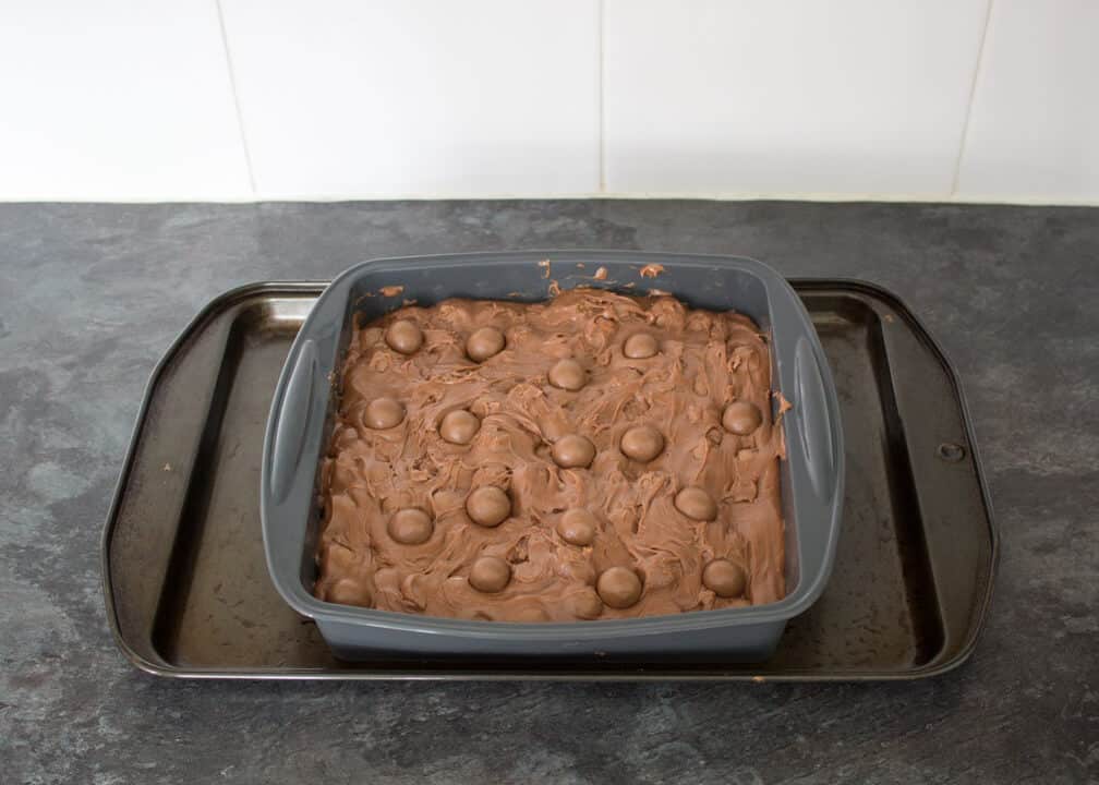 Maltesers Microwave Fudge mixture in a silicone pan with Maltesers pressed on top