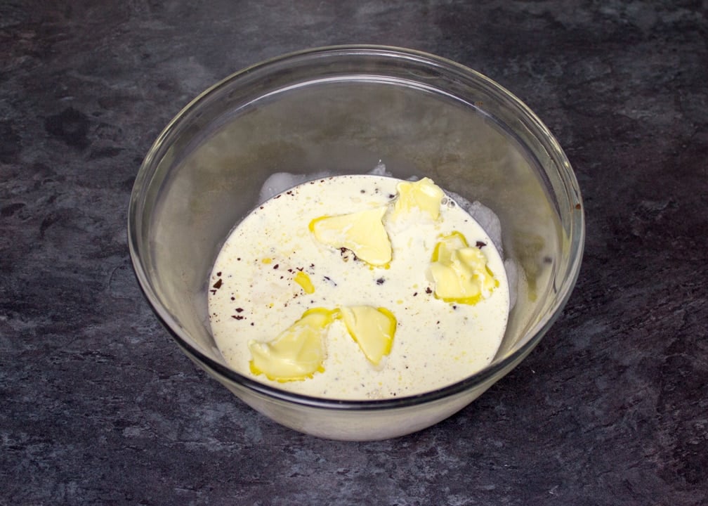 hot cream over butter & dark chocolate in a glass bowl