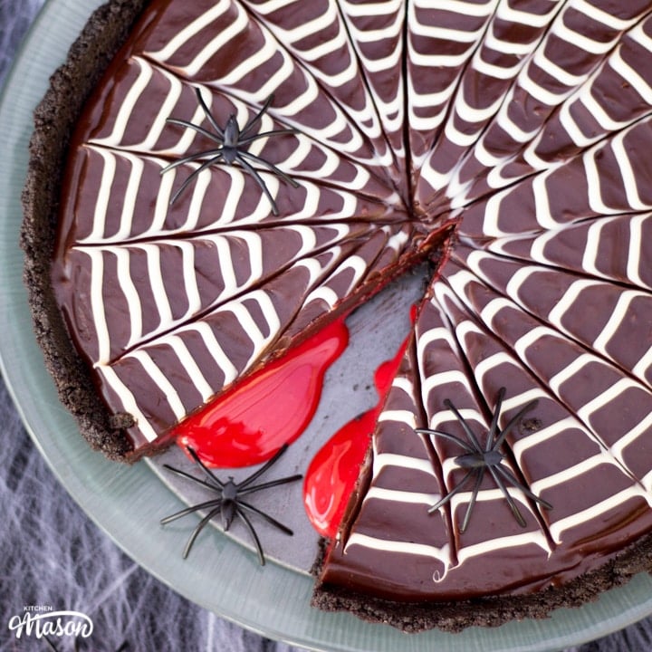 Halloween Dessert | No Bake Bloody Spider Web Chocolate Tart on a plate with plastic spiders
