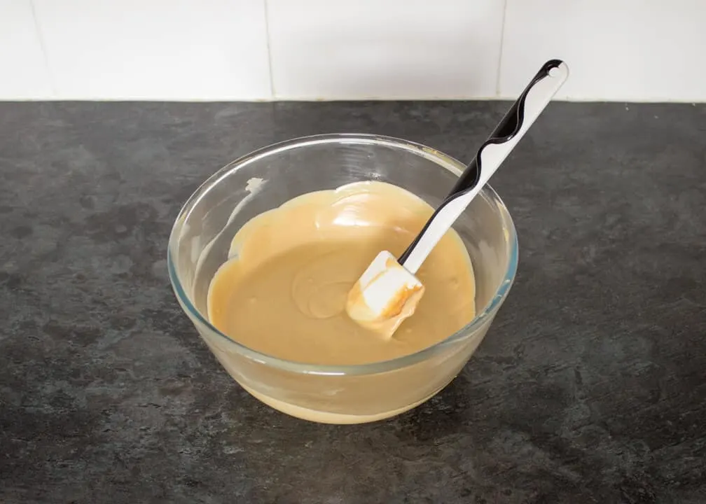Melted white chocolate and biscoff in a glass bowl