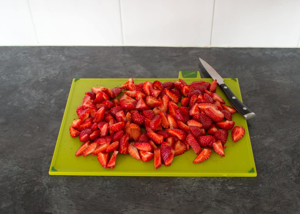 Strawberries & Cream Icebox Cake: sliced strawberries on a chopping board