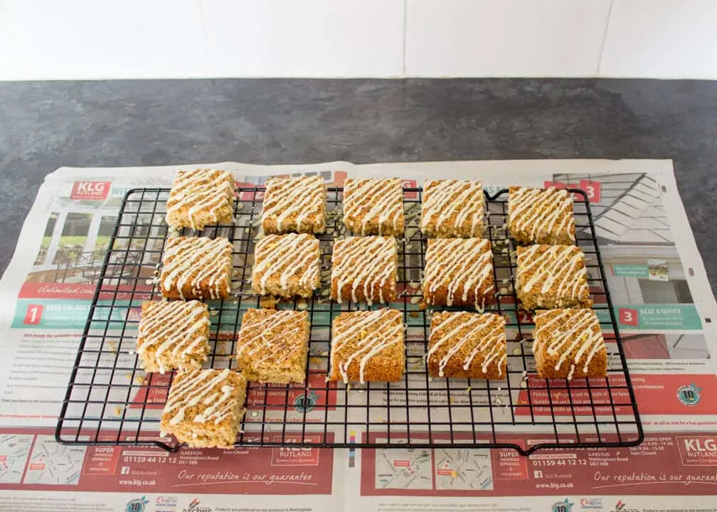 Lemon & White Chocolate Flapjack on a cooling rack over newspaper with lemon zest scattered on top