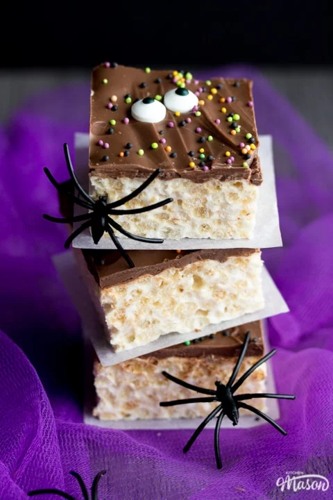 Rice Krispie Halloween Treats in a stack with fake black spiders crawling up