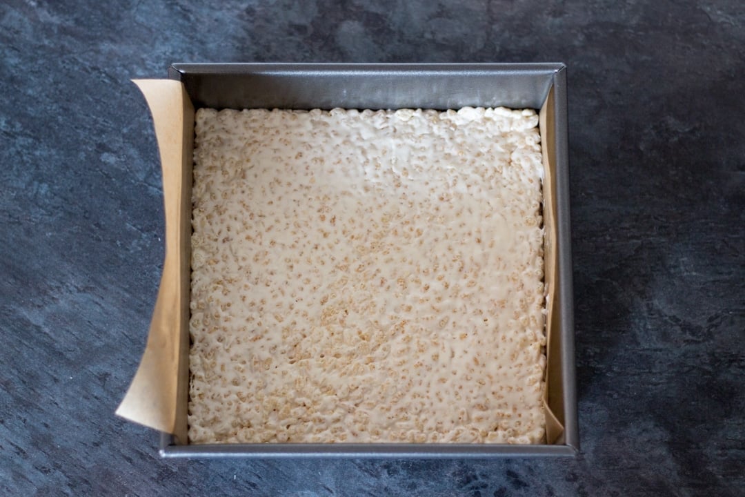 Rice Krispie marshmallow mixture pressed into a lined baking tray