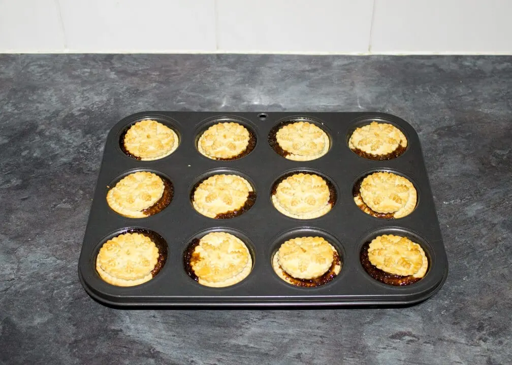 freshly baked shortcrust pastry mince pies in a muffin tin