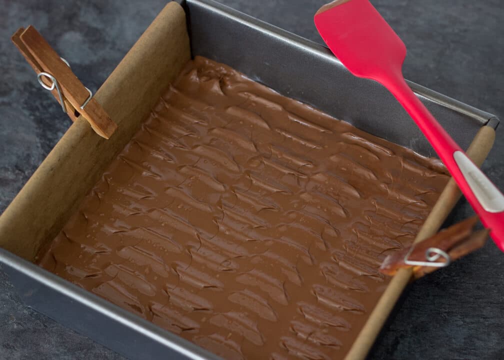 Snickers Millionaire Shortbread - Melted tempered chocolate on top in a baking tin