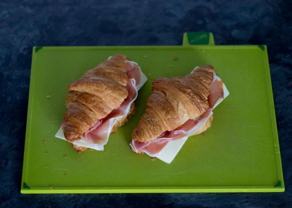 Croissant Sandwich with Prosciutto & Gouda on a Chopping Board