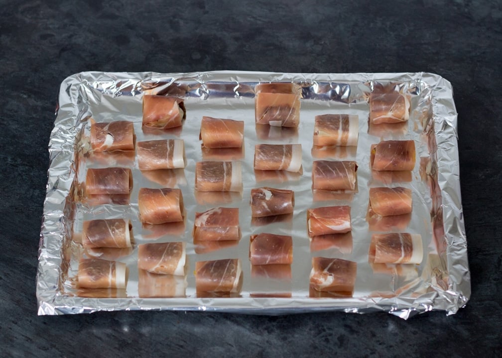 Party Snacks: Halloumi & sundried tomatoes wrapped in prosciutto on a baking tray
