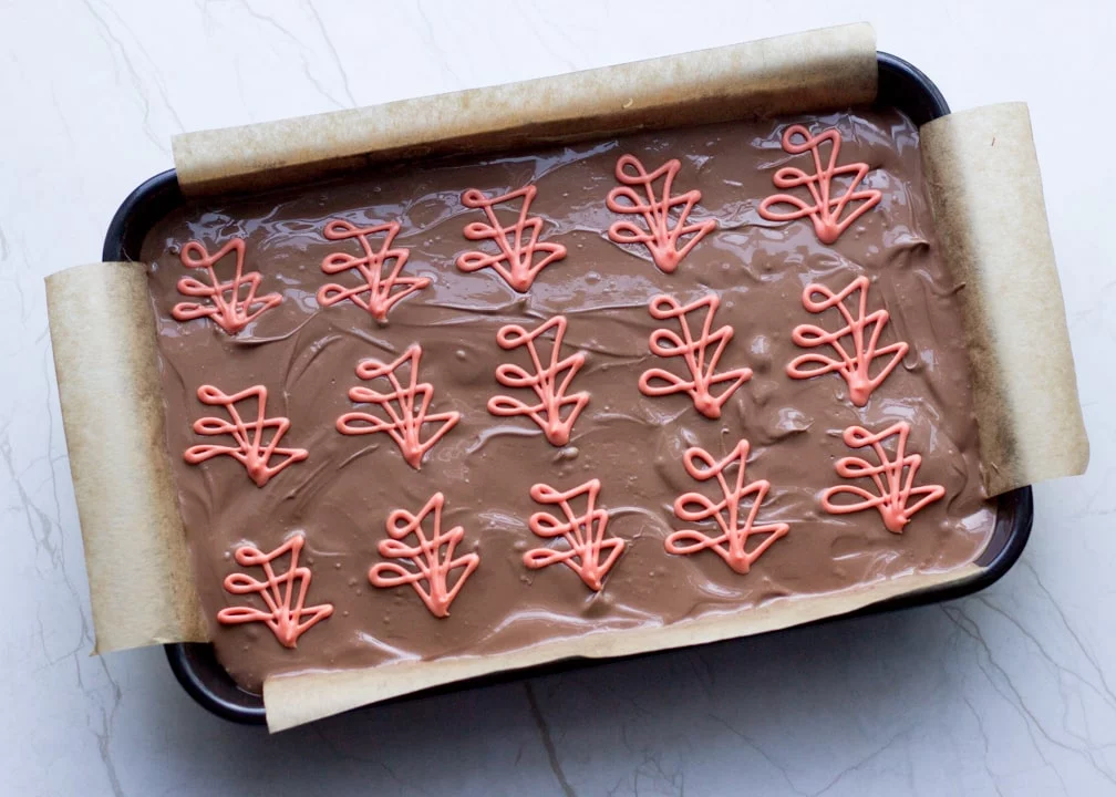 Chocolate Orange Caramel Shortbread: the orange white chocolate decorations on top of the chocolate layer in the baking tin
