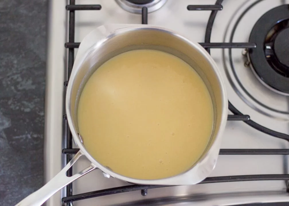 Chocolate Orange Caramel Shortbread: the dissolved caramel ingredients in a saucepan on the hob