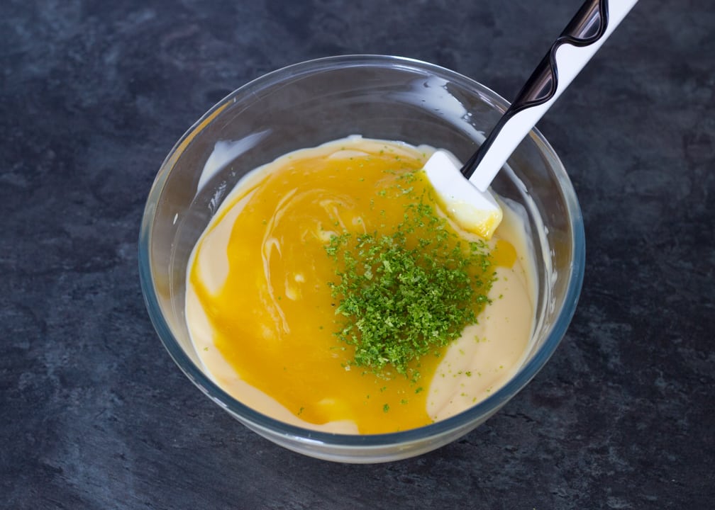 Homemade ice cream: custard base, mango puree and lime zest in a glass bowl