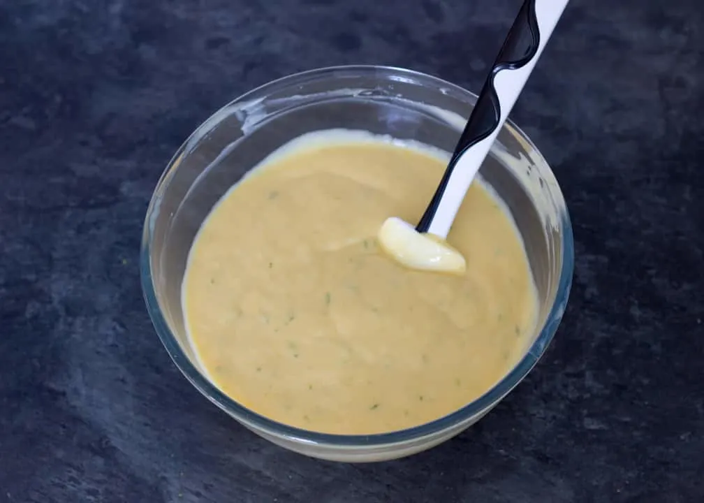 Homemade ice cream: custard base, mango puree and lime zest in a glass bowl mixed together