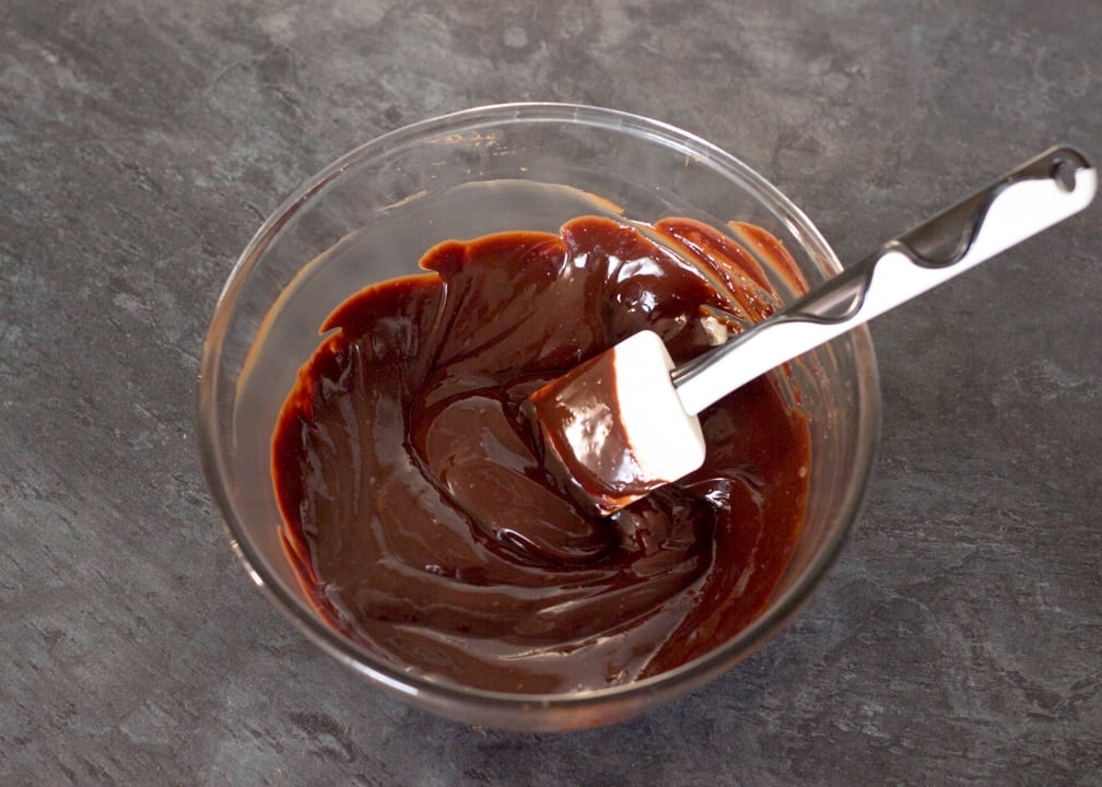 No Bake Caramel Chocolate Tart Recipe: Caramel chocolate tart filling in a glass bowl with a spatula