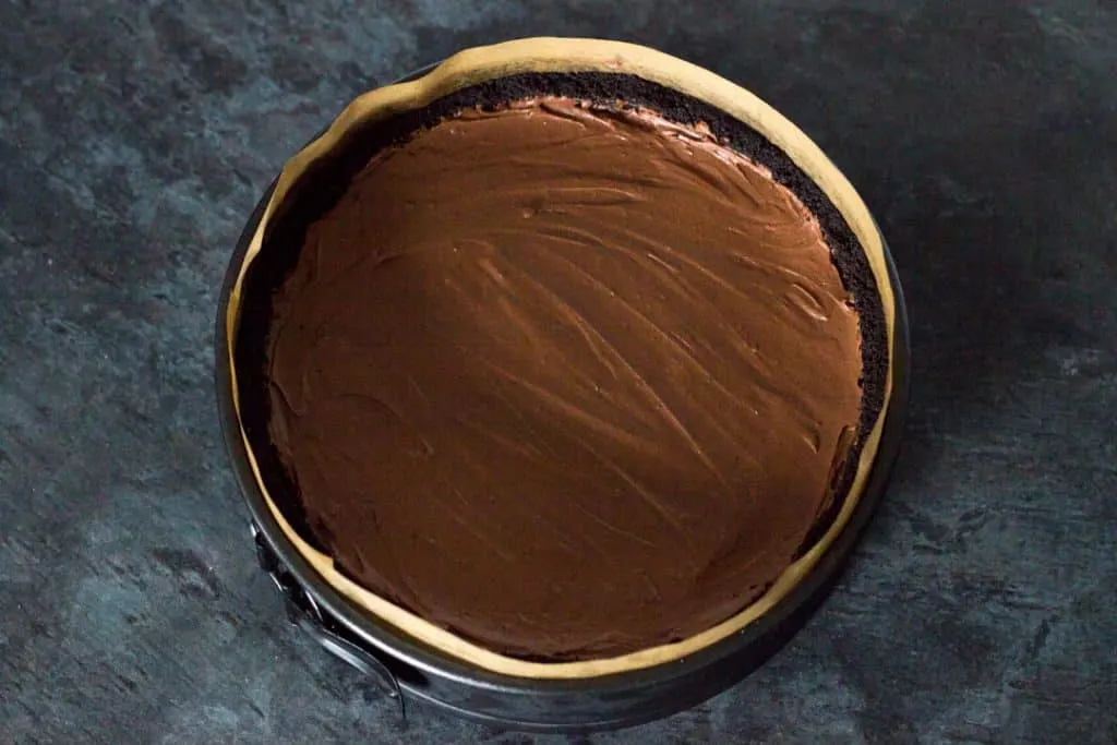 No bake chocolate cheesecake filling smoothed out over a prepared base