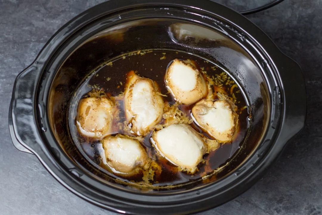 Chicken teriyaki recipe: cooked chicken thighs in a slow cooker covered in teriyaki sauce