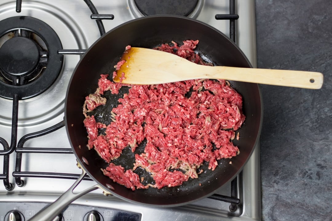 olive oil and beef mince in a large saucepan cooking (easy spaghetti bolognese)