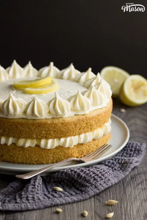 dairy free / vegan lemon cake on a plate with a fork and squeezed lemons