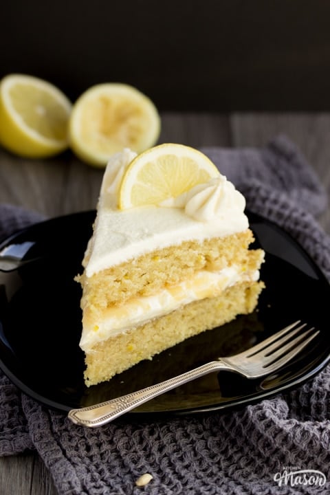 slice of dairy free / vegan lemon cake on a black plate with a fork