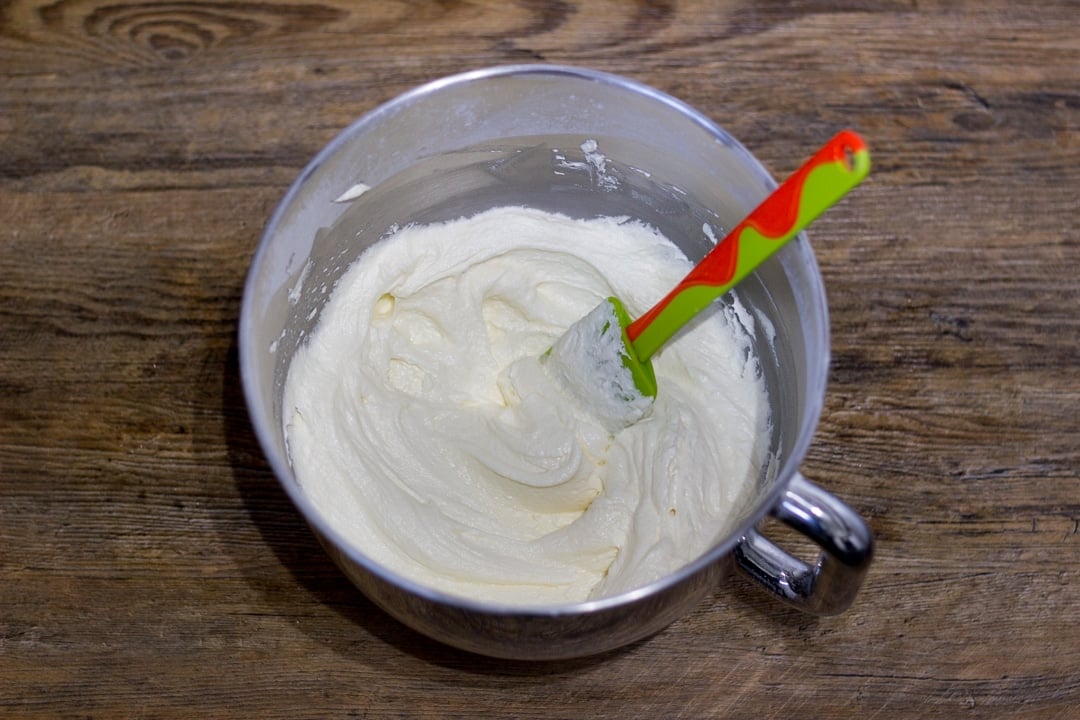 dairy free / vegan lemon frosting in a metal bowl with a spatula