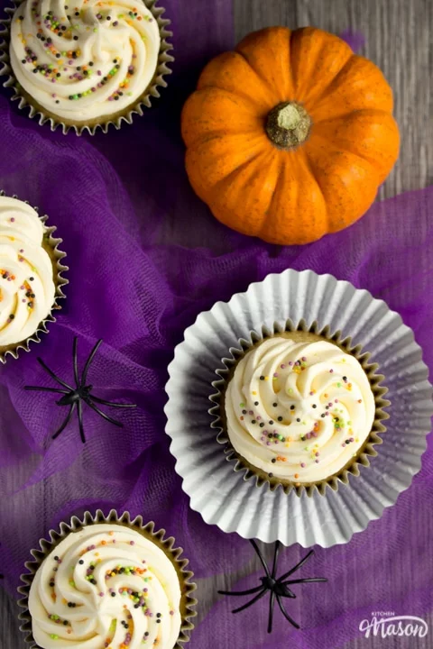 halloween cupcakes on purple tuille with a pumpkin and fake spiders