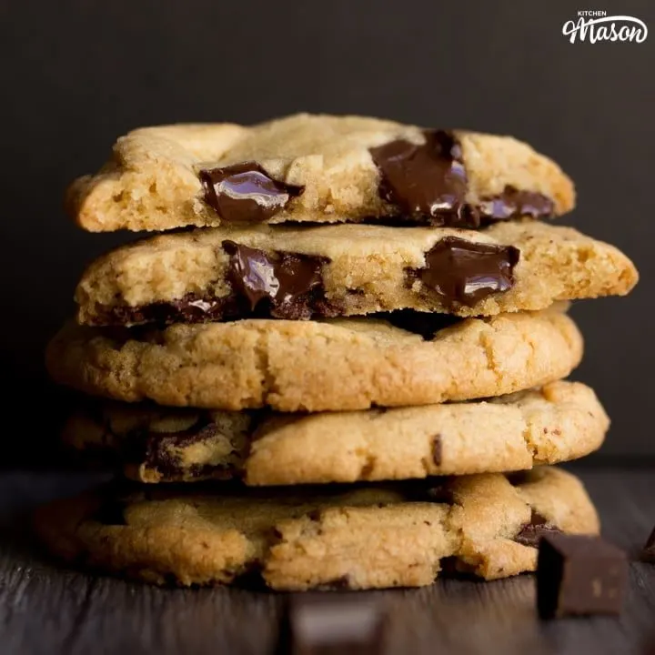 vegan chocolate chip cookies broken in half with melting chocolate chips in a stack