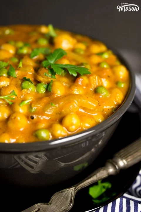 coconut chickpea curry in a bowl with parsley scattered on top