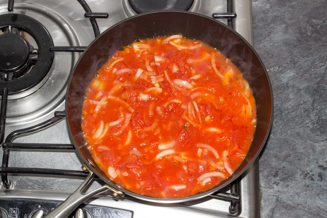 tomatos and onion simmering in a pan