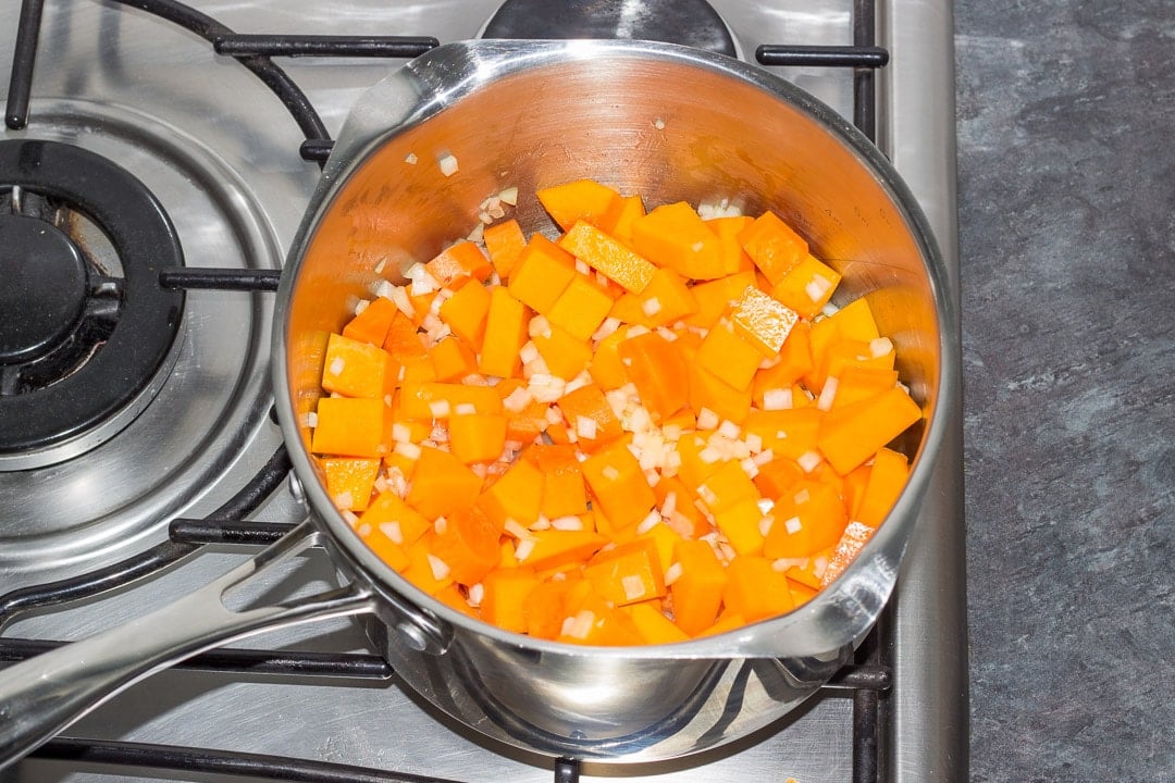 vegetables frying in a large pot on the hob