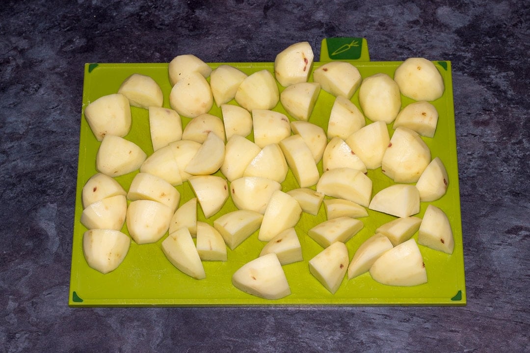 peeled and chopped potatoes on a chopping board
