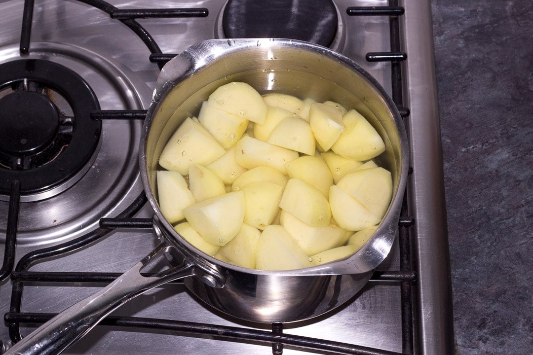 prepared potatoes in a saucepan of water on the hob
