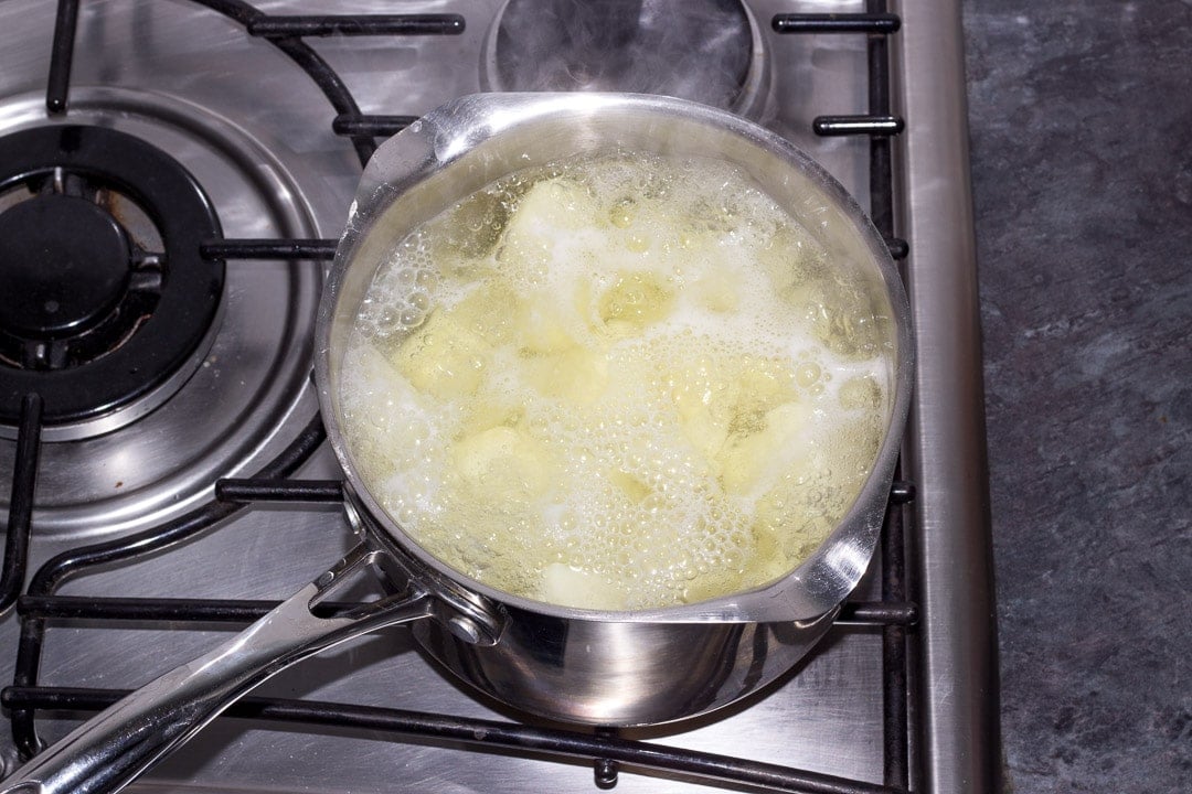 potatoes boiling in a saucepan on the hob