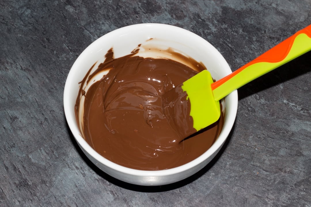 melted dairy free dark chocolate in a bowl with a spatula
